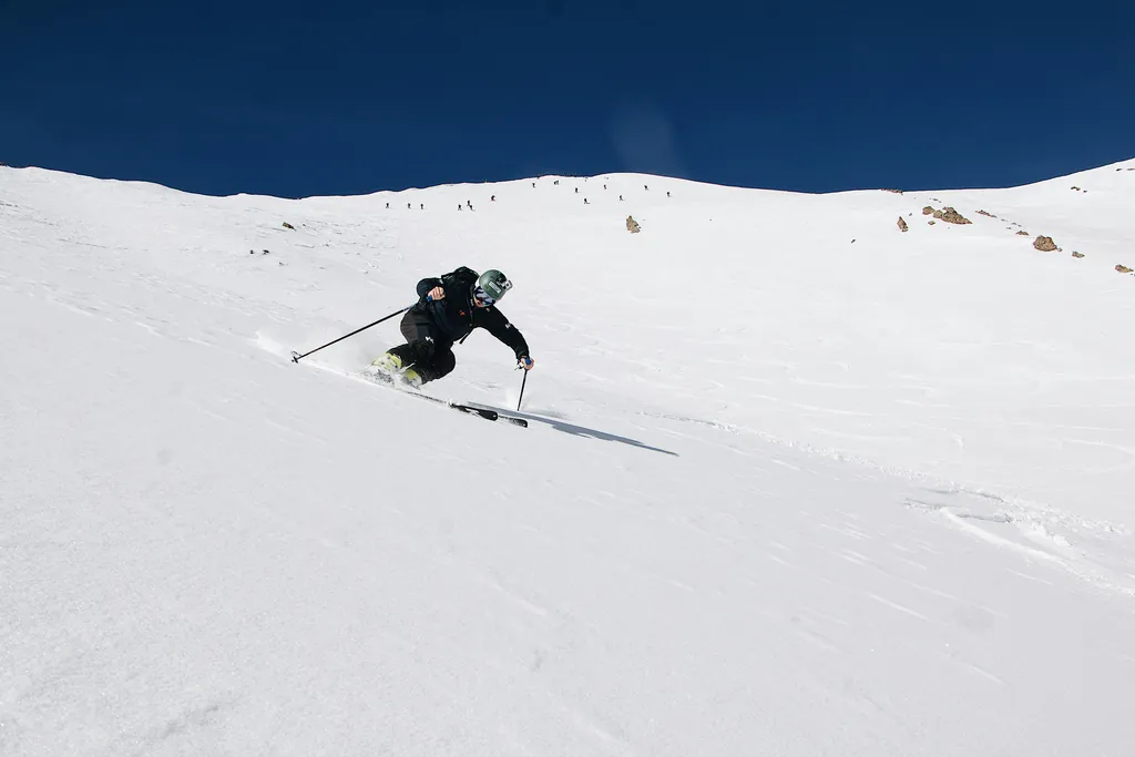 A skier descends a snowy slope during a winter tour in Kyrgyzstan
