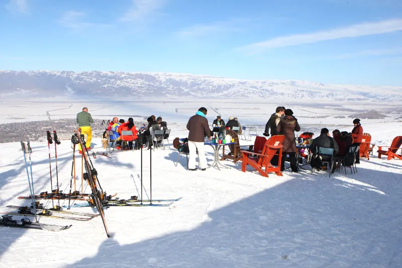 Skiers and snowboarders in a café on the slopes of the Orlovka ski resort in Kyrgyzstan in winter