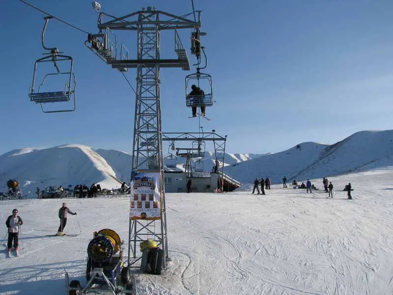 Chairlift and snow cannons at the Orlovka ski resort in Kyrgyzstan