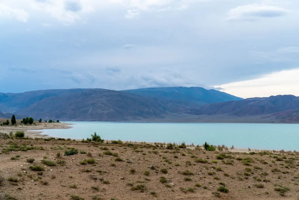Панорамный вид на Орто-Токойское водохранилище в Кыргызстане в сезон половодья на фоне гор