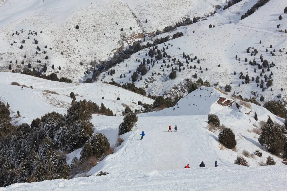 Vacationers skiing down the slopes of the Kashka-Suu ski base in Kyrgyzstan